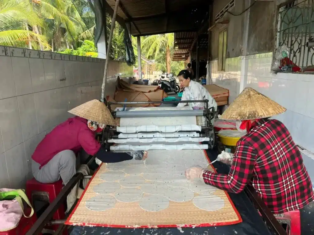 Làng nghề bánh phồng Sơn Đốc với các công đoạn giã nếp, cán bánh và phơi bánh – phản ánh không khí lao động của người dân xứ Dừa.